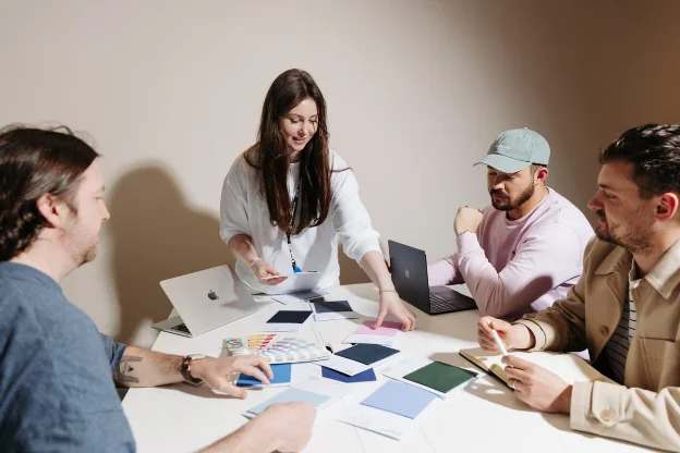 A team around a table with colour swatches, planning a gifting brief